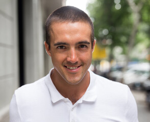 Obraz premium Portrait of young man in white T-shirt walking on street