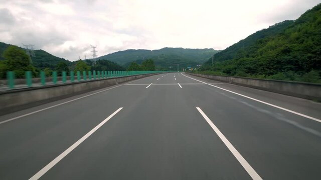 fast moving over modern highway, three traffic lane road between hills