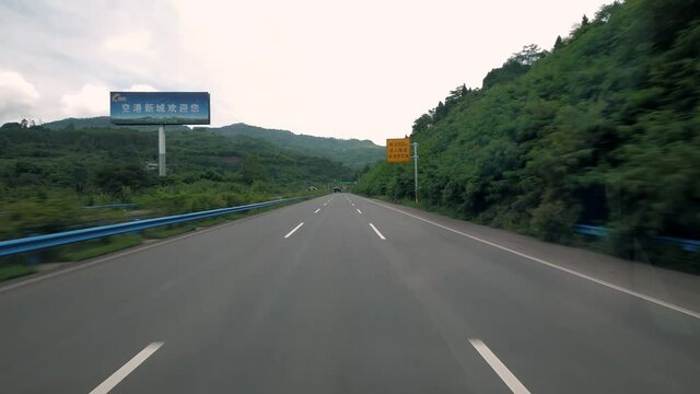 fast moving over modern highway in China, three traffic lane road between hills