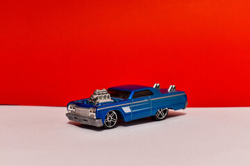 exhibici&oacute;n carro azul fondo rojo