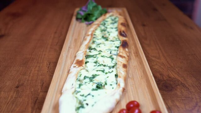 big Cheese Manakeesh Plating With tomato on a wooden plate , nice lighting - 4K
