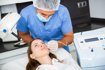 Female client getting carbon dioxide injections for face skin rejuvenation in clinic of aesthetic...
