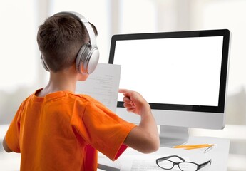 Young stylish school child studying homework during online lesson on a laptop
