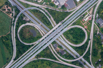 Aerial view of highway junctions with roundabout. Bridge roads shape circle in structure of architecture and transportation concept. Top view. Urban city, Bangkok at sunset, Thailand