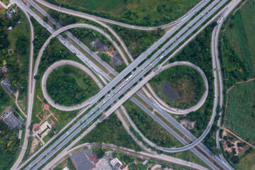 Aerial view of highway junctions with roundabout. Bridge roads shape circle in structure of architecture and transportation concept. Top view. Urban city, Bangkok at sunset, Thailand