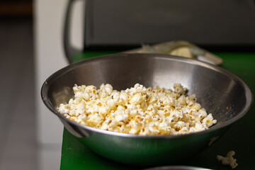 A bowl of freshly made popcorn sits on counter
