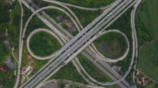 Aerial view of highway junctions with roundabout. Bridge roads shape circle in structure of architecture and transportation concept. Top view. Urban city, Bangkok at sunset, Thailand