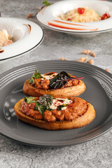 Two delicious bruschettas with eggplant aubergine spread on a plate