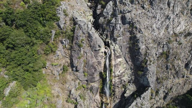 Aerial descending towards magnificent waterfall High stone Cliff - Mizarela