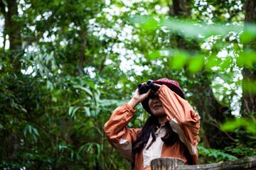 森で野鳥観察をする女性