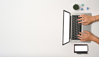 Above view man using laptop computer on white table.