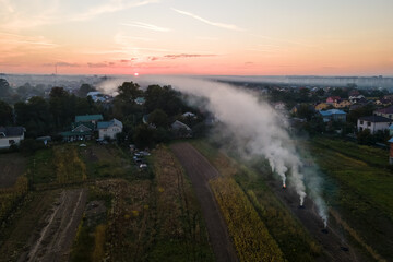 Aerial view of agricultural waste bonfires from dry grass and straw stubble burning with thick...