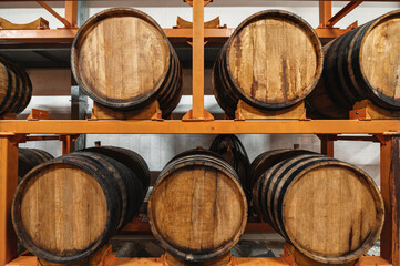 Wooden casks full of hard alcohol drinks stand on large rack