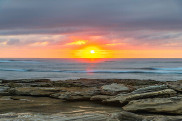 Sunrise seascape with rocky foreground