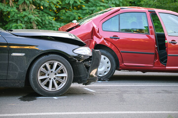 Damaged in heavy car accident vehicles after collision on city street crash site. Road safety and...