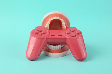 Joystick in the teeth of the jaw model. Minimal creative gaming concept © splitov27