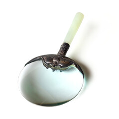 A magnifying glass to enlarge the vision with a metal handle and the handle is a light green jade stone, retro style placed on a white background. Isolate.