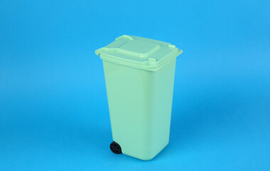 Toy trash can on blue background