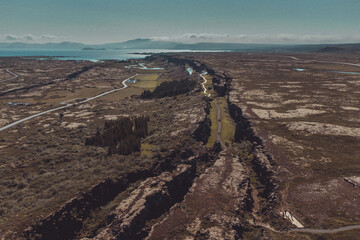 Aerial view of colliding tectonic plates at Thingvellir in Iceland. Drone view of plates connecting forming a longvalley, on a summer day.