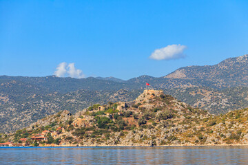 Fototapeta premium View of ancient Lycian town Simena with fortress on a mount on the coast of the Mediterranean sea in Antalya Province, Turkey