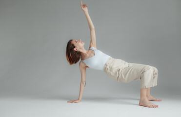 Naklejka premium Young stylish woman dancing contempo on gray background. Charisma and grace