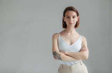 Obraz premium Portrait of self-styled stylish modern woman with short hair on gray background