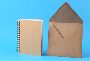 Craft notebook and envelope on blue background