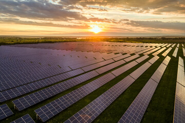 Aerial view of large sustainable electrical power plant with many rows of solar photovoltaic panels...