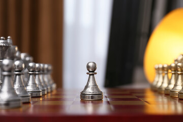 Pawn piece in middle of chessboard indoors