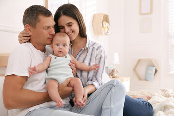 Fototapeta premium Happy family with their cute baby on bed at home