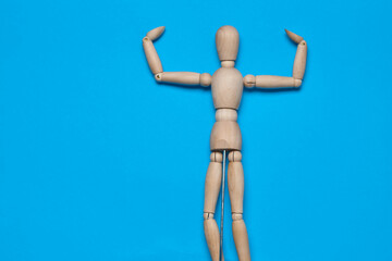 wooden figure mannequin object posing blue background