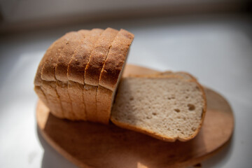 Round loaf of freshly baked sourdough bread with knife on cutting board, top view. Artisan bread with seeds on marble table. Rustic sourdough bread.