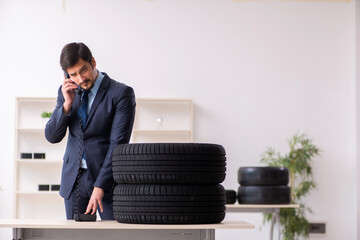 Young man selling tires in the office