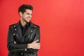Young unshaven man wearing leather jacket smiling aside