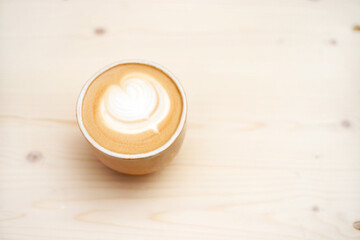 Fresh flavored coffee art is on the wooden table.
