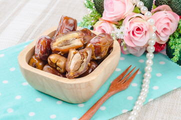 Dried dates fruit in wooden bowl.
