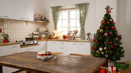 Beautiful interior with modern kitchen and christmas tree. New years eve celebration concept. empty room with star xmas decoration and lights on the wall in bright cooking place indoors