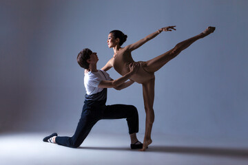 Dance Photography Ideas. Professional Ballet Dance Couple Performing Together in Studio While Girl Posing in Bodysuit Against White Background.