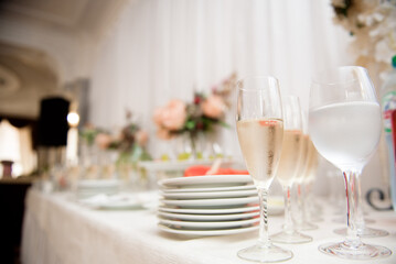 Wine glasses with a cool delicious champagne or white wine at the bar. Alcohol background.