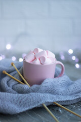 knitting needles, a cup of coffee with pink marshmallows.Christmas lights.