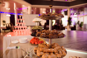 Candy bar. White wedding cake standing of festive table with deserts, tartlet and cupcakes. Wedding.