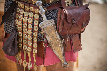 Centurion girding a pugio, a dagger used by roman soldiers as a sidearm - obrazy, fototapety, plakaty