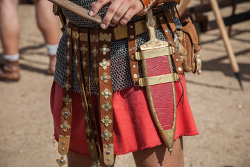 Centurion girding a pugio, a dagger used by roman soldiers as a sidearm - obrazy, fototapety, plakaty