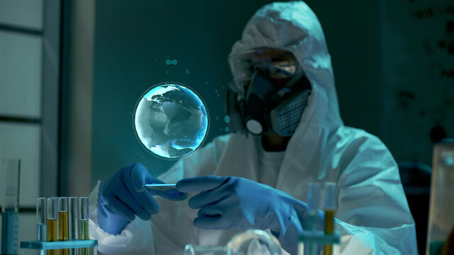 Scientist in ppe suit with planet hologram working in biochemical lab