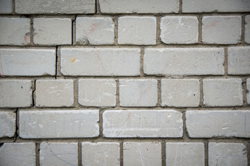 Painted in grey white colors old vintage empty brick wall background with copy space. Rustic cemented house stonewall texture with grunge surface. Shabby Building Facade With Damaged Plaster