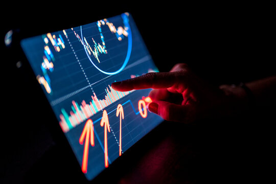 Businesswoman pointing at stock market data on digital tablet