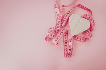 Measure tape on the pastel pink background. Mock up for body slimming, weight loss or dressmaker's offer or other ideas. Empty place for text, logo or object