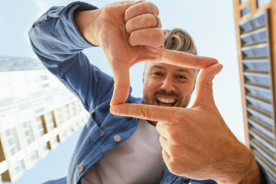 Happy man making rectangle shape with fingers