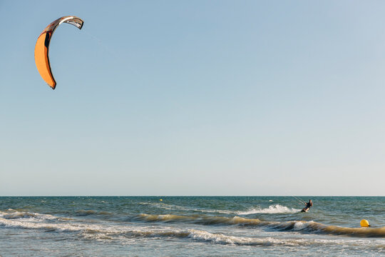Mid adult man kiteboarding on sea during sunny day