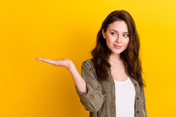 Portrait of attractive girl holding on palm copy space gift present surprise isolated over vibrant...